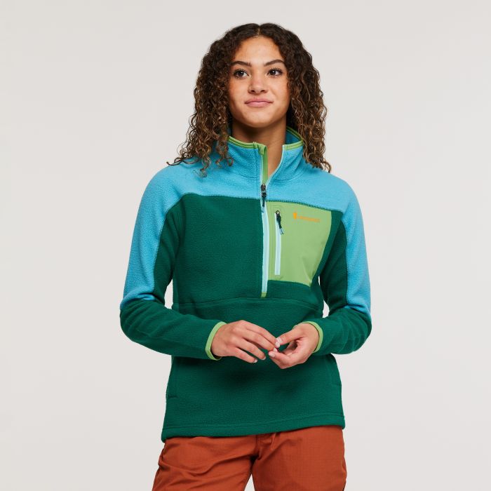 woman wearing green Cotopaxi Abrazo half-zip fleece