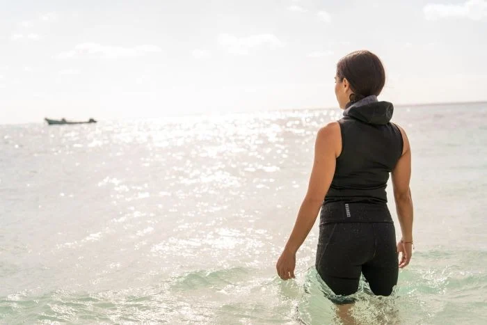 girl wearing bare Exowear Hooded Vest enterting ocean