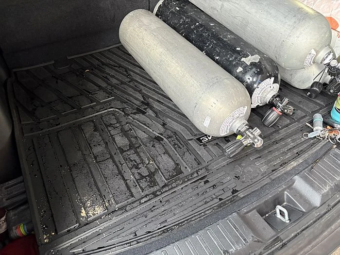 3W car mats with scuba tanks on top of them in trunk of a car