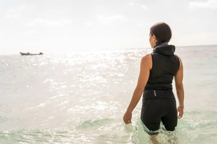 girl wearing bare Exowear Hooded Vest enterting ocean