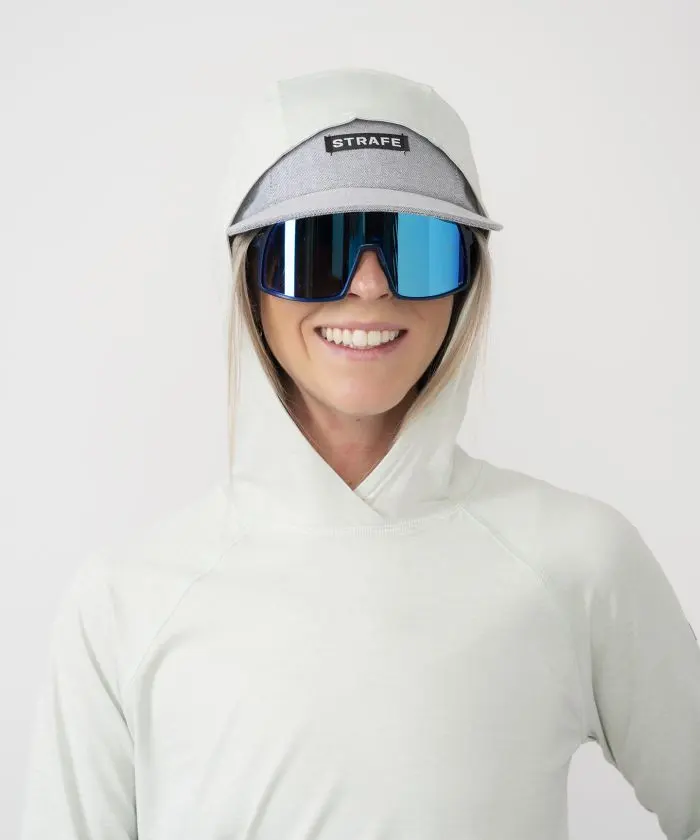 Woman in sunglasses wearing Strafe Sun Hoodie in surf color