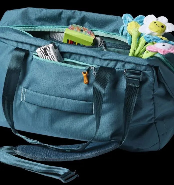 Cotopaxi Viaje 45L in blue with an assortment of things flowing out of its pockets