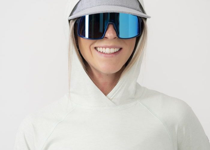 Woman in sunglasses wearing Strafe Sun Hoodie in surf color