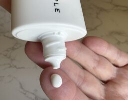 Daygleamer Mineral Sunscreen Serum SPF 34 by Well People on finger